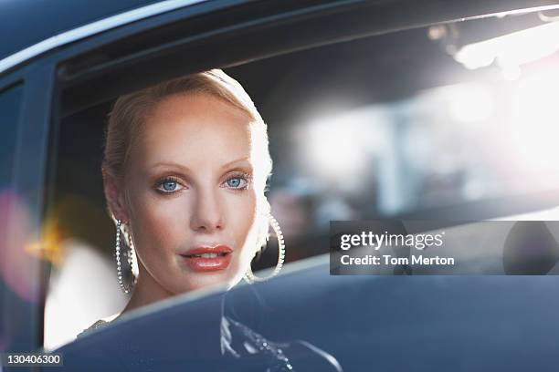 woman sitting in backseat of car - limo stockfoto's en -beelden