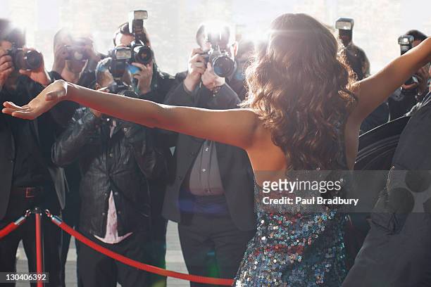 celebrity posing for paparazzi on red carpet - roped off stockfoto's en -beelden