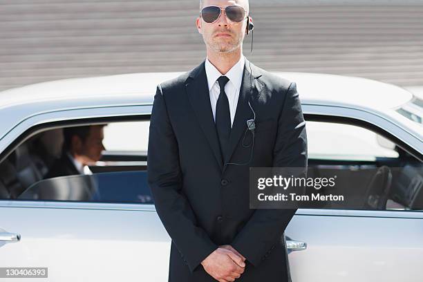 security guard standing by car - bodyguard stock pictures, royalty-free photos & images