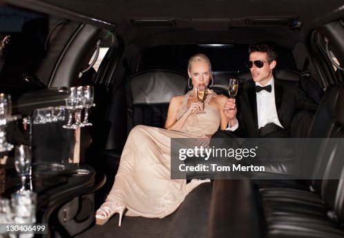 Coppia bere champagne in limousine Coppia bere champagne in limousine