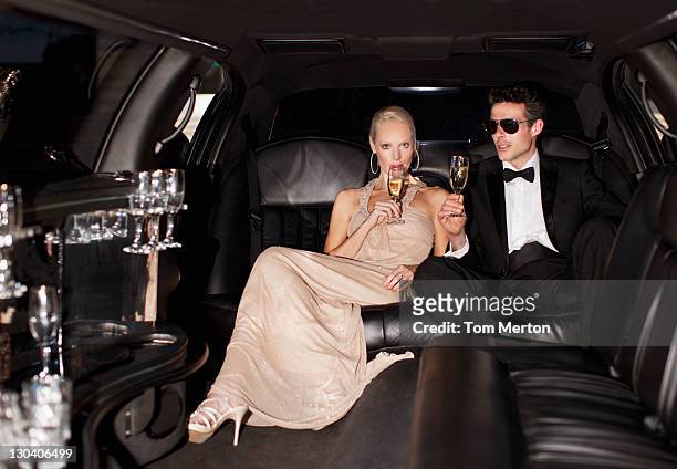 couple drinking champagne in limo - formele kleding stockfoto's en -beelden