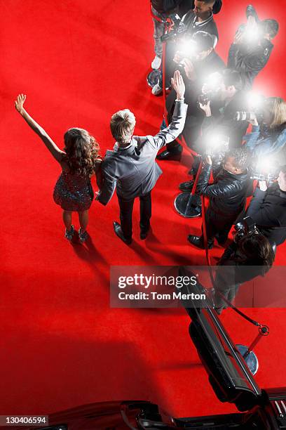 celebrities waving to paparazzi on red carpet - red carpet paparazzi stock pictures, royalty-free photos & images