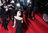 Celebrity posing for paparazzi on red carpet
