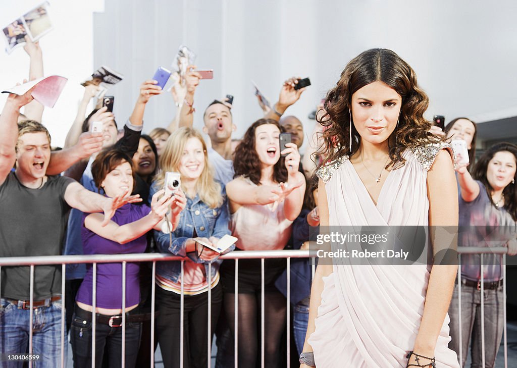 Fans reaching towards celebrity on red carpet