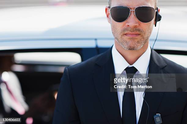 bodyguard wearing earpiece - guarding stock pictures, royalty-free photos & images