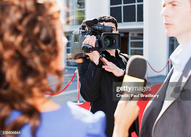 cameraman taping celebrity on red carpet - press conference microphone stock pictures, royalty-free photos & images