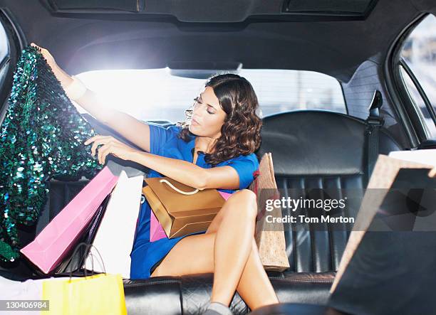 woman with shopping bags in backseat of limo - celebrities shopping stock pictures, royalty-free photos & images