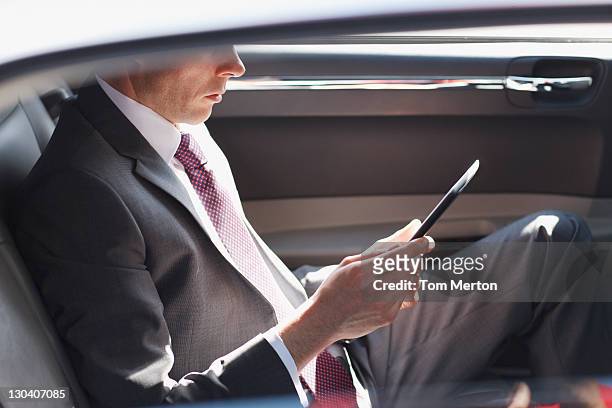 politician reading in backseat of car - millionnaire stock pictures, royalty-free photos & images