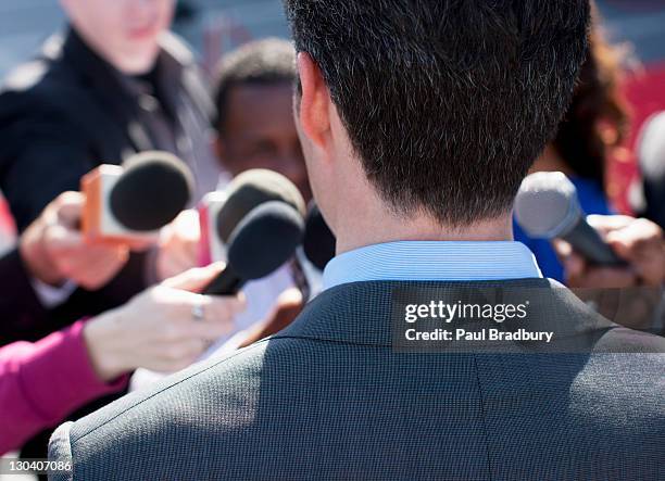 politician talking into reporters' microphones - england press conference stock pictures, royalty-free photos & images