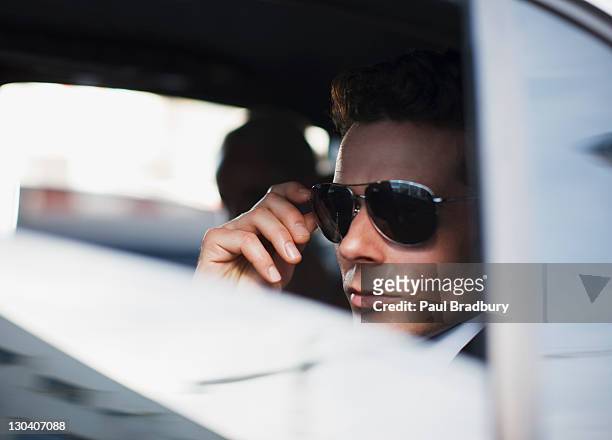 man wearing sunglasses in backseat of car - star sunglasses stock pictures, royalty-free photos & images