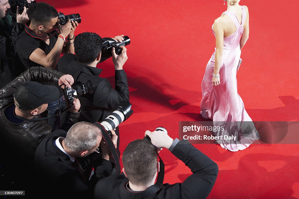 Paparazzi taking pictures of celebrity on red carpet
