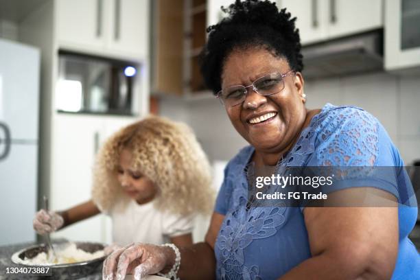 ritratto di nonna che cuoce con la nipote a casa - ritratto nonna cucina foto e immagini stock
