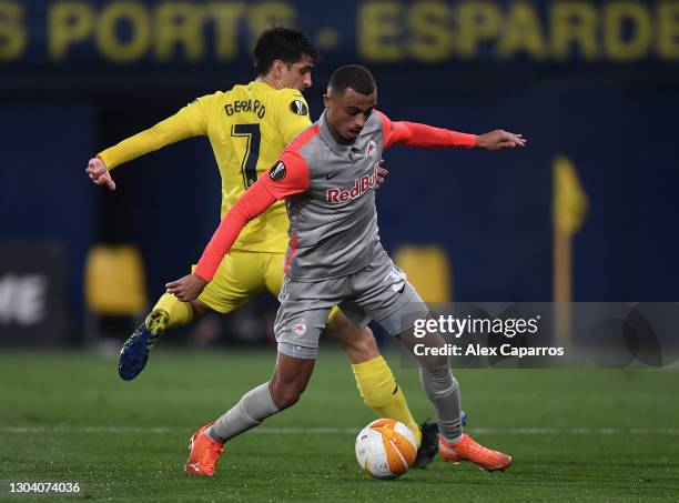 Gerard Moreno of Villarreal battles for possession with Antoine Bernede of Red Bull Salzburg during the UEFA Europa League Round of 32 match between...