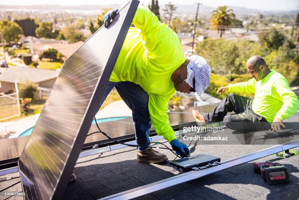 Hispanic Man Connecting Solar Panels to Micro Inverters