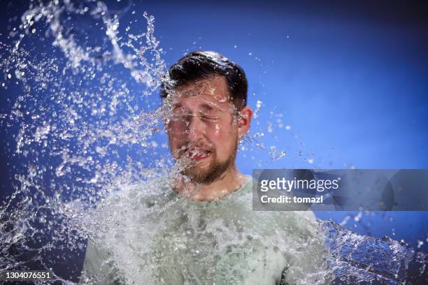 hombre siendo salpicado con agua - man splashed with colour fotografías e imágenes de stock
