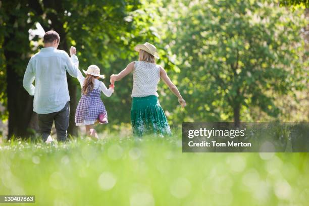 famille marchant main dans la main dans le parc - daily life in london photos et images de collection