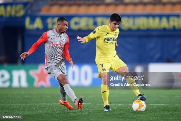 Gerard Moreno of Villarreal CF controls the ball under pressure from Antoine Bernede of RB Salzburg during the UEFA Europa League Round of 32 second...