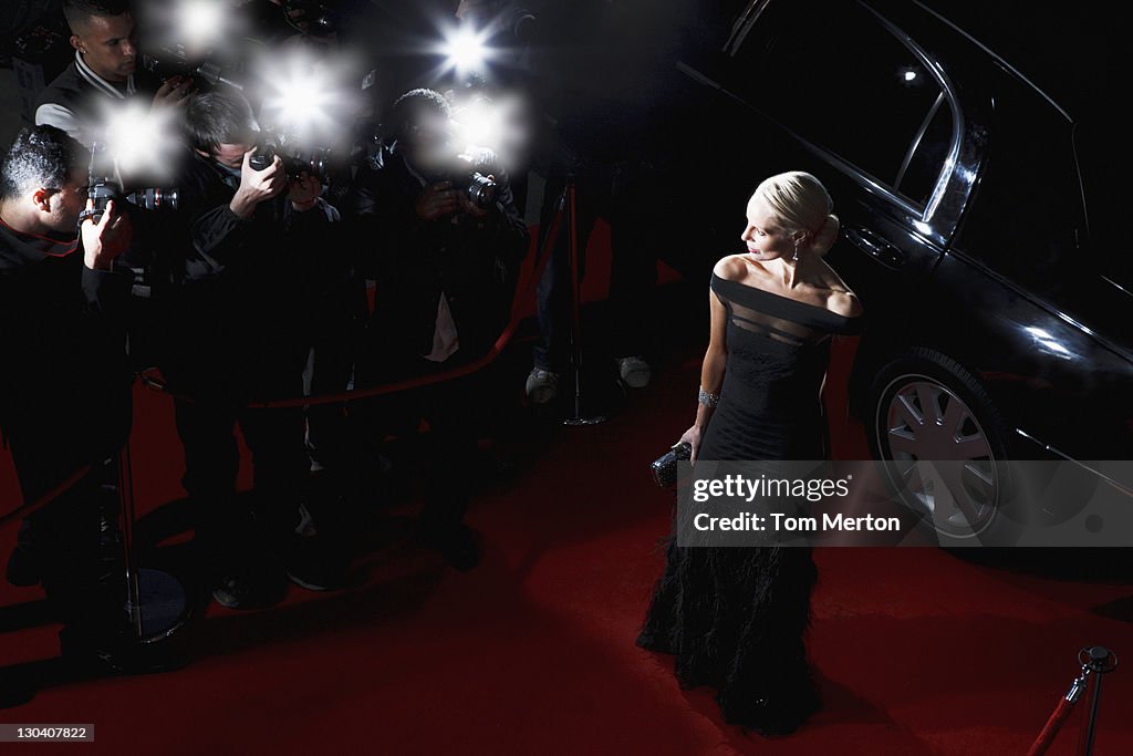 Celebrity posing for paparazzi on red carpet