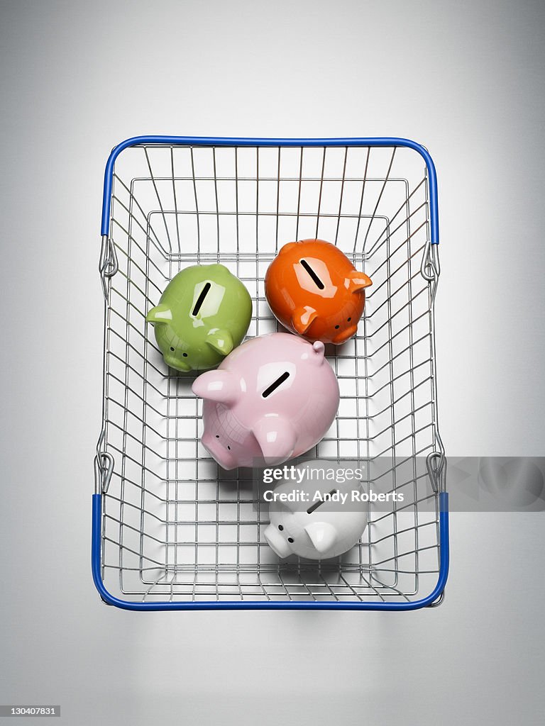 Piggy banks in shopping basket