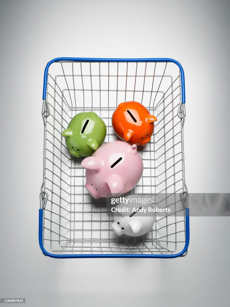 Piggy banks in shopping basket