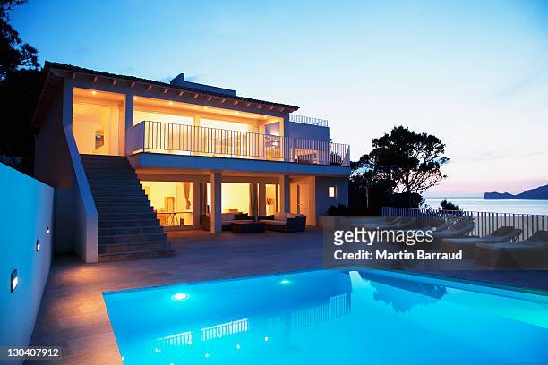 pool outside modern house at twilight - swimming pool night stock pictures, royalty-free photos & images