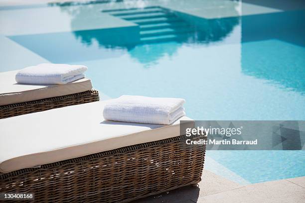 folded towels on lounge chairs beside pool - luxury stock pictures, royalty-free photos & images