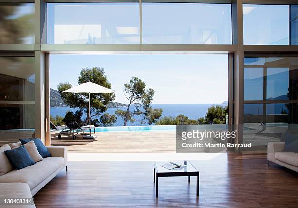 sofa and sliding doors in open modern house - sliding door stock pictures, royalty-free photos & images