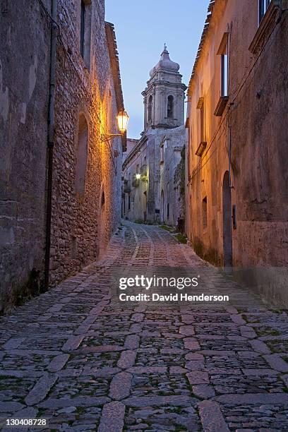 cobbled alleyway of old city lit up at night - erice imagens e fotografias de stock