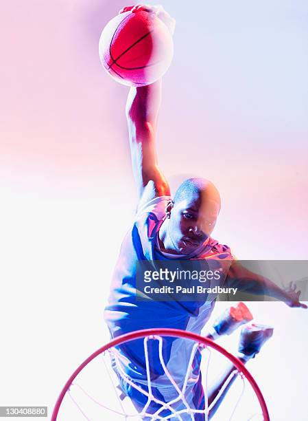 blurred view of basketball player dunking - slam dunk stock pictures, royalty-free photos & images