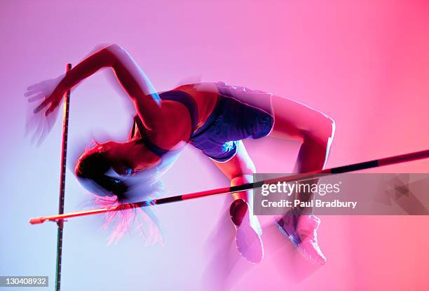 sportler curling über high jump - leichtathletik stock-fotos und bilder