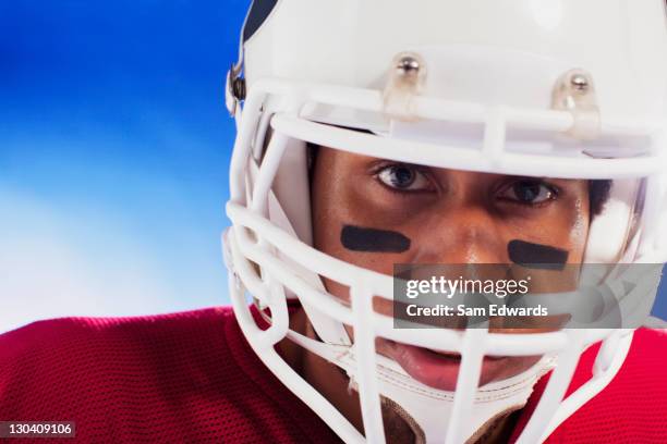 close up of football player wearing helmet - football player face stock pictures, royalty-free photos & images