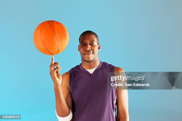 basketball player balancing ball on one finger - basketball jersey stock pictures, royalty-free photos & images