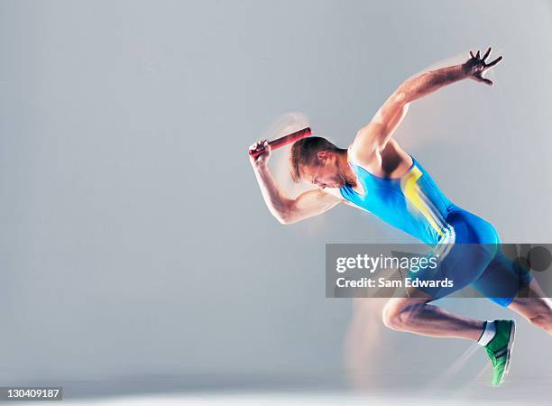 blurred view of athlete running with baton - baton relay bildbanksfoton och bilder