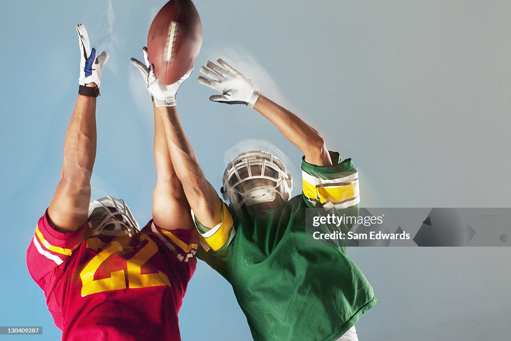 Blurred view of football players reaching for ball