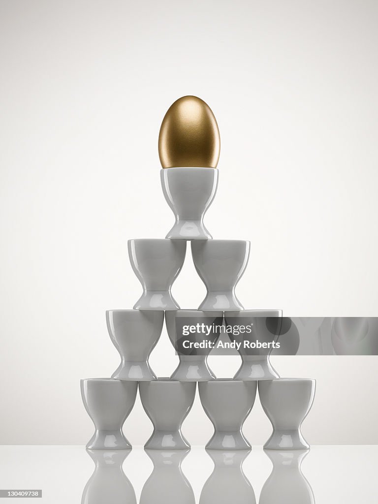 Stacked egg cups with golden egg