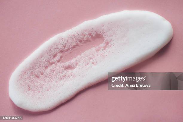 white smear of foam on pastel pink background. selfcare is a trend of the year - foam material stockfoto's en -beelden