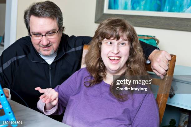 gelukkige gehandicapte jonge vrouw trots op haar keus tijdens virtueel leren thuis - cerebal palsy stockfoto's en -beelden