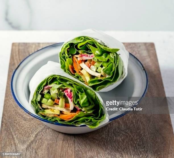 healthy vegan wraps on a plate on white background - wrap sandwich stock-fotos und bilder