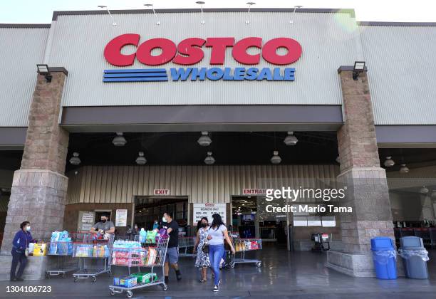 Shoppers walk in front of a Costco store on February 25, 2021 in Inglewood, California. Costco announced plans to increase its minimum wage to $16...
