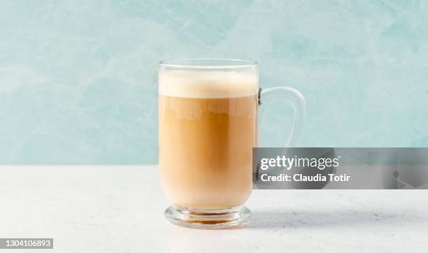 cup of chai latte on blue background - カフェラテ ストックフォトと画像