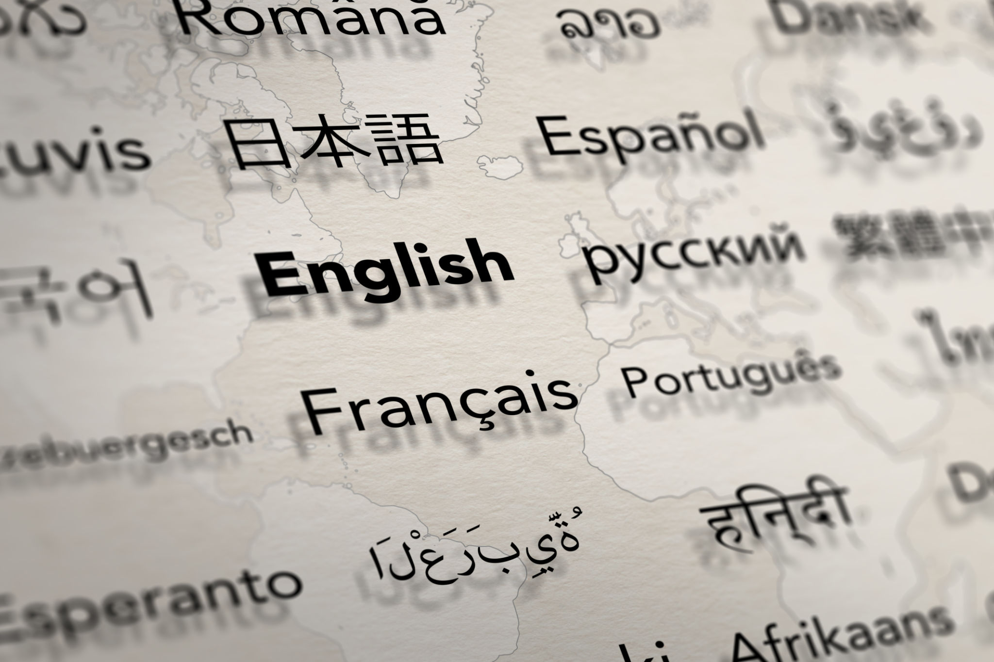 Several important languages on paper with world map background. Several important languages on paper with world map background.
