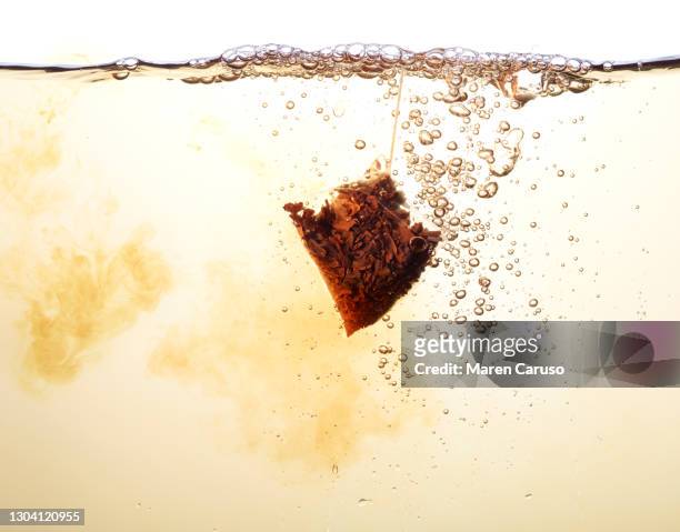 tea bag floating in liquid - steeping stock pictures, royalty-free photos & images