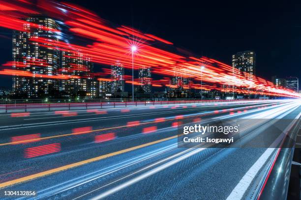 cityscape and red light trails at night - auto rot stock-fotos und bilder