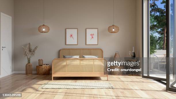 bedroom interior in beige color with wicker bed furniture, pendant lights, balcony and posters on the wall. - tidy room stock pictures, royalty-free photos & images
