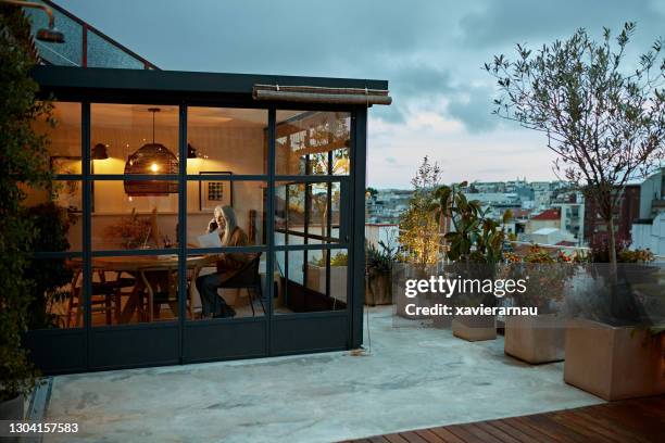 mid 60s female telecommuter working in barcelona home office - patio lights stock pictures, royalty-free photos & images