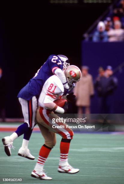 Russ Francis of the San Francisco 49ers gets tackled by Herb Welch of the New York Giants during the NFC WildCard Game on December 29, 1985 at Giants...