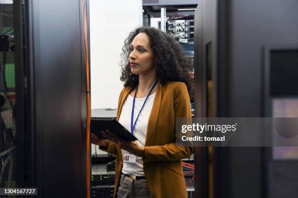 profesional de ti femenina en sala de servidores - computer cable fotografías e imágenes de stock