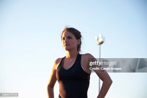 athlete with sun shining on face standing confidently on track - hot fitness models female stock pictures, royalty-free photos & images