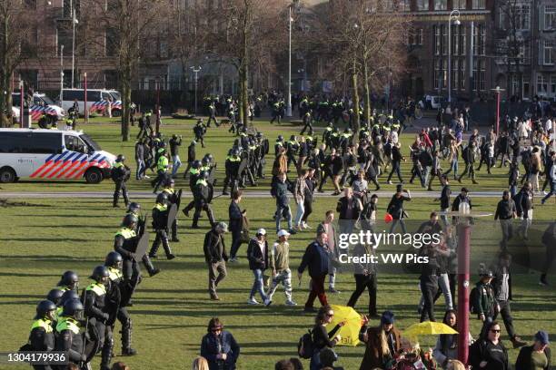 Anti-riot police disperse anti-lockdown protesters during an illegal demonstration against coronavirus measures at the Muaeumplein on February 21,...