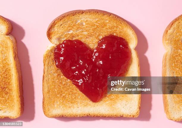 toast with heart shaped jam closeup from above - marmelade stock-fotos und bilder